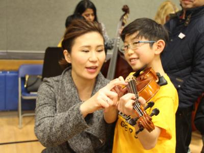 son and mother playing instrument